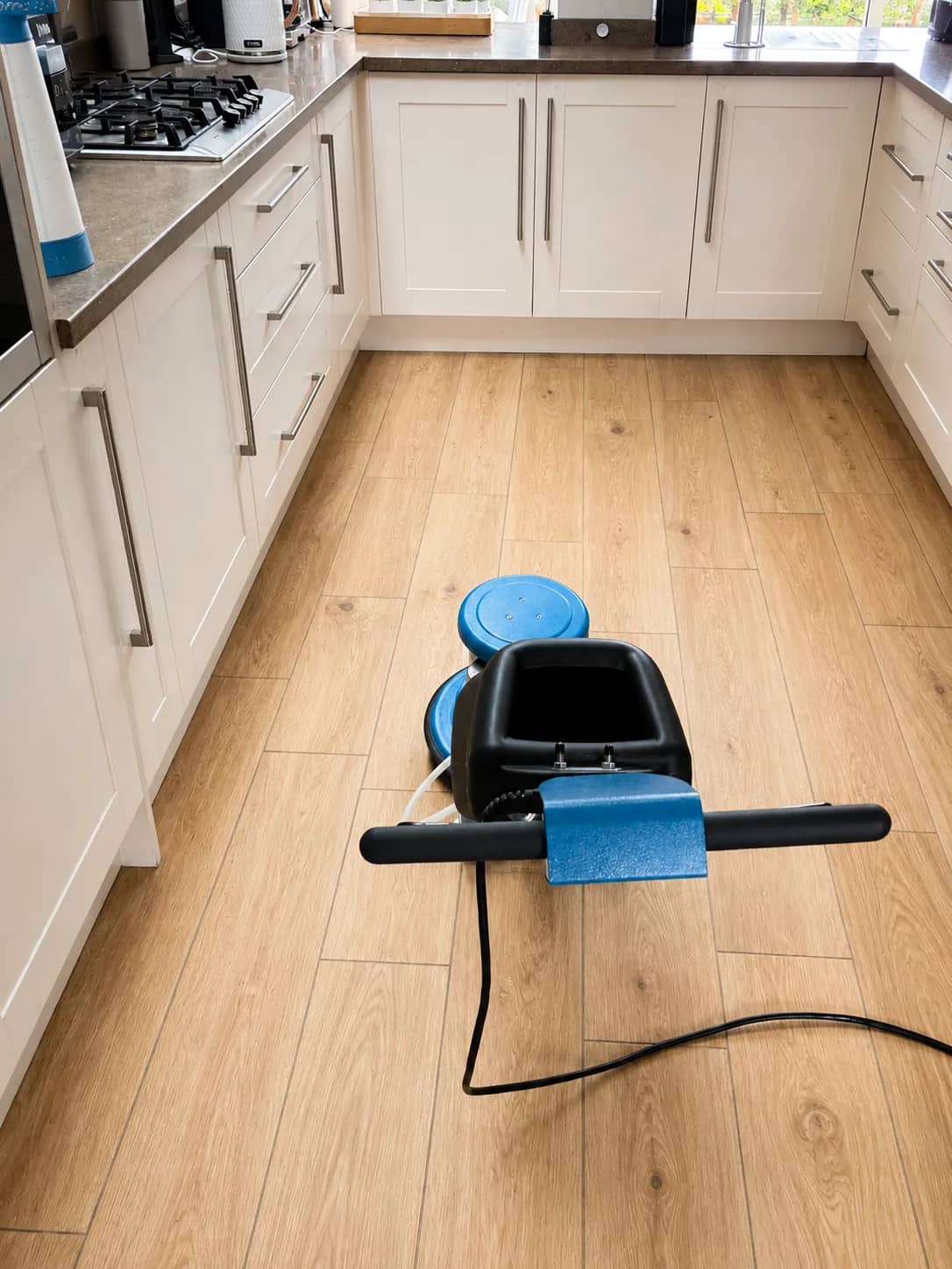 Hard floor extraction machine cleaning a kitchen tile floor.