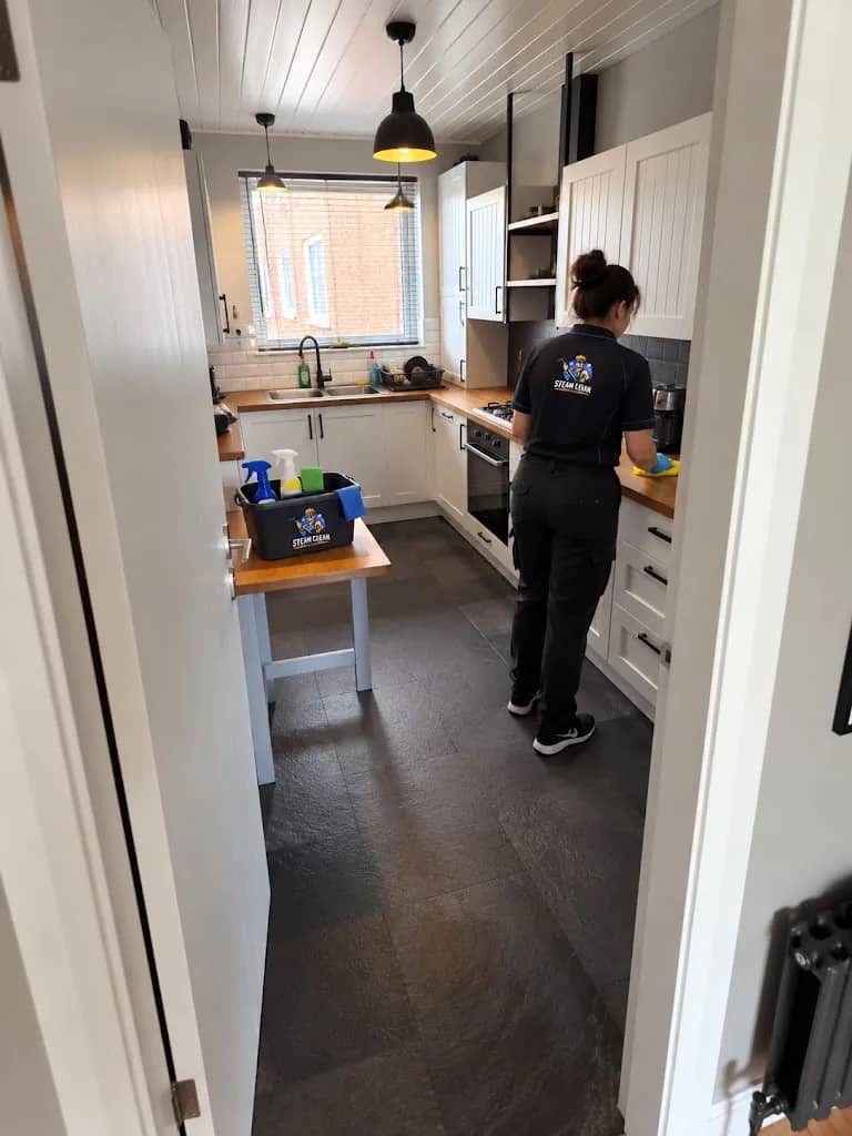 Steam Clean Master technician cleaning a narrow galley kitchen in a terraced home