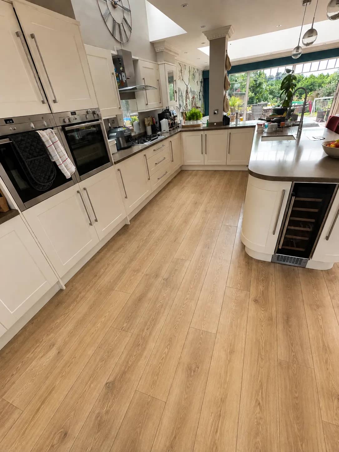 Open-plan kitchen with oak-style hard flooring after professional cleaning